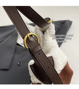 Detail of golden adjustable metal buckle on white faux fur and brown suede shoulder bag