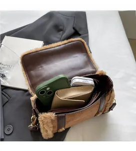 Detail view of the spacious inner compartment of the brown plush crossbody handbag
