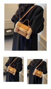 Detailed close-up of brown suede bag with beige faux fur trim and dual buckle straps