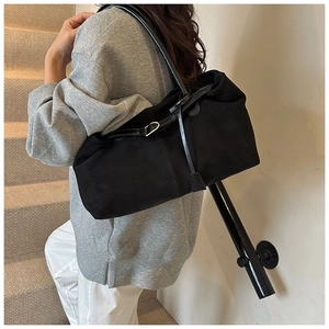 Detail showing the matte texture and premium leather strap of the black tote bag