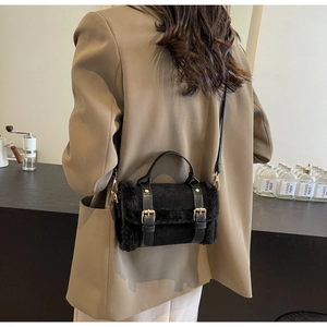 Detail showing plush black fur texture and golden buckles on a stylish crossbody bag