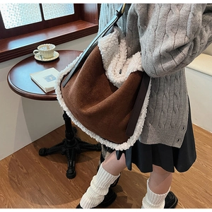 Détail du sac hobo en daim marron avec garniture en fausse fourrure blanche douce d'hiver