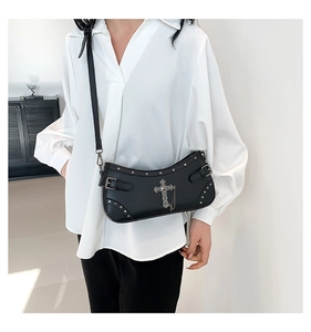 Detail of black punk style crescent bag with silver cross, chains and metallic studs
