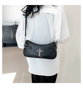 Detail view of black gothic crossbody bag with silver cross, studs and punk metal chains