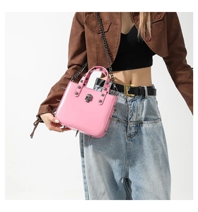 Close-up of pink gothic crossbody bag featuring silver studs and metal skull detail