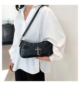 Detail of gothic black PU crossbody bag with silver cross pendant and metal chains