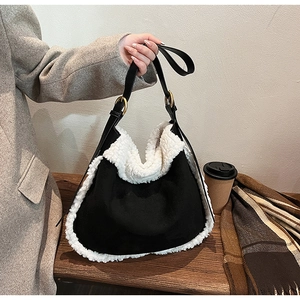 Detail of hobo bag with black faux suede and white shearling trim by coffee table