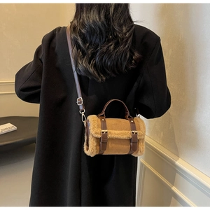 Dettaglio del bordo in peluche su borsa in pelle scamosciata marrone con manici