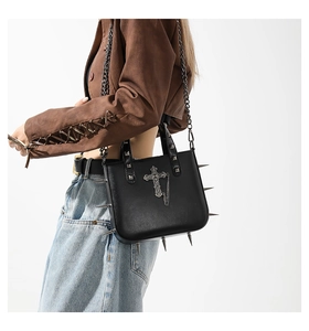 Gothic punk crossbody bag featuring metal spikes, cross charm, and stud details on model
