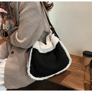 Detail of suede crossbody bag with fleece trim and golden buckle in an autumn setting