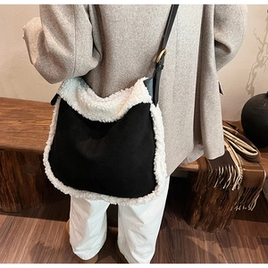 Détail du sac bandoulière en daim noir avec garniture en peau de mouton blanche