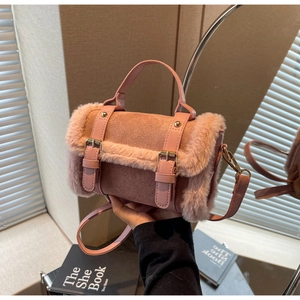 Dettaglio borsa a cilindro rosa in peluche con cinturini decorativi e fibbie metallo