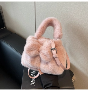 Vue détaillée du sac seau en fausse fourrure rose avec un grand nœud en peluche doux