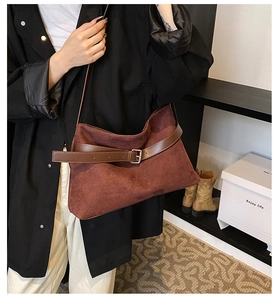 Détail de la texture cuir givré bordeaux avec boucle métallique sur le sac à bandoulière