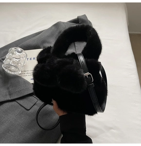 Vue détaillée de la texture en fausse fourrure noire et de la bandoulière du sac seau