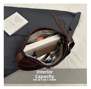 Internal capacity of brown leather tote showing spacious storage for books and gadgets