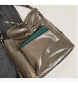 Detail einer braunen Kunstledertasche mit magnetischer Fronttasche für ein Smartphone