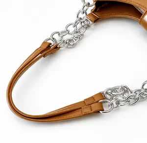 Detailed shot of brown leather handle with silver metal chain links and fine stitching