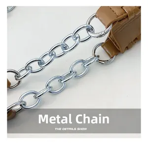 Detailed close-up of premium silver hardware chain and brown leather strap stitching