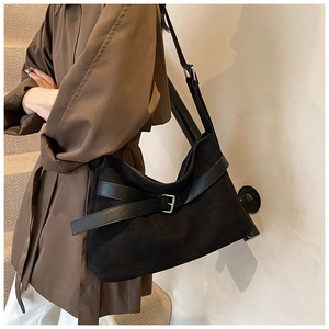 Détail du sac à bandoulière en daim noir mat avec sangle en cuir et boucle en argent