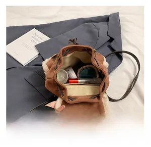 Internal storage detail of brown suede bucket bag featuring cozy faux shearling trim