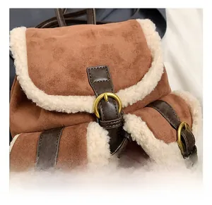 Detail of vintage suede bucket bag with faux shearling trim and golden metal buckle