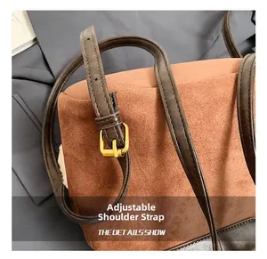 Macro shot of adjustable leather strap with bronze buckle on brown suede bucket bag