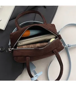 Top view of brown suede boston bag showing large interior capacity for phone and wallet