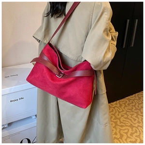 Grand sac cabas en daim rouge avec boucle métallique porté par un mannequin