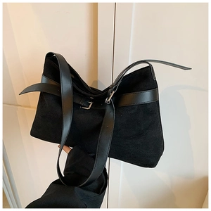 Détail du sac cabas en daim noir avec boucles métalliques et bandoulières en cuir lisse