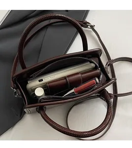 Interior view showing the organized storage and zipper pocket of the vintage leather handbag