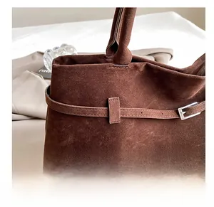 Detailed view of the dark brown matte leather tote featuring a retro decorative buckle strap