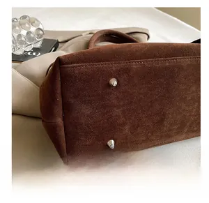 Detail shot of the durable suede tote bag base featuring protective metal studs