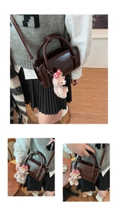 Detailed close-up of dark coffee patent leather Boston bag with a cute plush bear charm