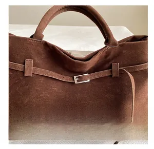 Detail showing the silver metal buckle and brown suede strap on a large tote bag