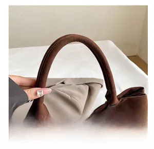 Detail of the thickened handle and soft suede texture on a vintage brown tote bag