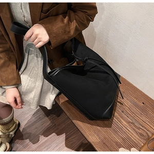 Close-up of black matte bucket bag with bow detail on a vintage aesthetic background