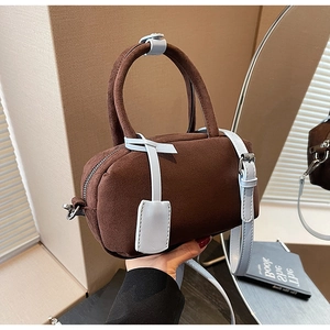Detail of matte brown suede texture with contrasting light blue leather handles and silver hardware