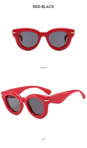 Detail view of red frame sunglasses with black lenses and golden metal accents