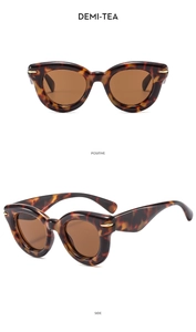 Detail view of tortoiseshell cat-eye sunglasses with gold rivets and brown lenses