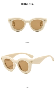 Detail view of beige retro sunglasses with tea lenses and golden metal accents