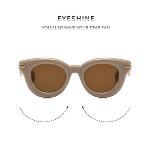 Vista frontale dettagliata di occhiali da sole tondi cat-eye con montatura kaki e rivetti