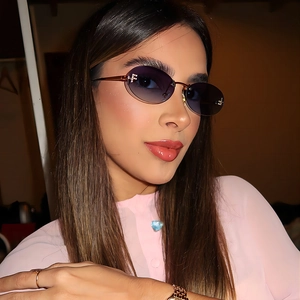 Detail of oval rimless sunglasses with gradient blue lenses and gold metal frame logo