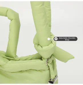 Detailed view of adjustable shoulder strap and metal hardware on green padded nylon bag