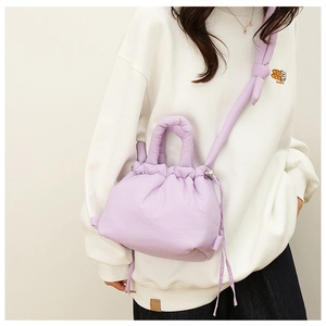 Detail of lavender quilted nylon crossbody bag featuring a soft ruched drawstring closure