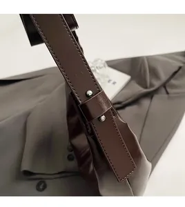 Detail of handcrafted stitching and smooth edges on a dark brown leather shoulder bag