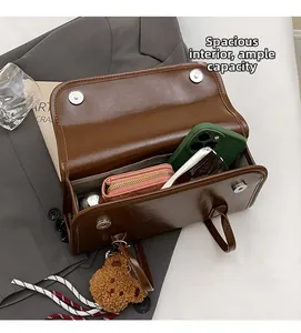 Spacious interior of dark brown leather shoulder bag with phone and wallet inside
