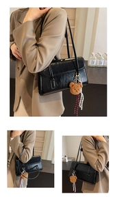 Dettaglio borsa hobo nera lucida con ciondolo a forma di orsetto e cordino decorativo