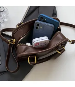 Detail view of brown vintage pillow bag showing interior space with phone and mints