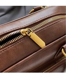 Close-up of brown leather texture with polished gold zipper and fine stitching detail